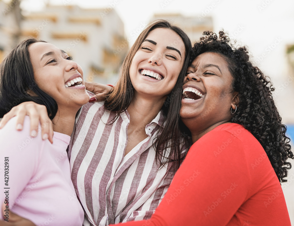 a racially diverse group of women embracing each other and laughing